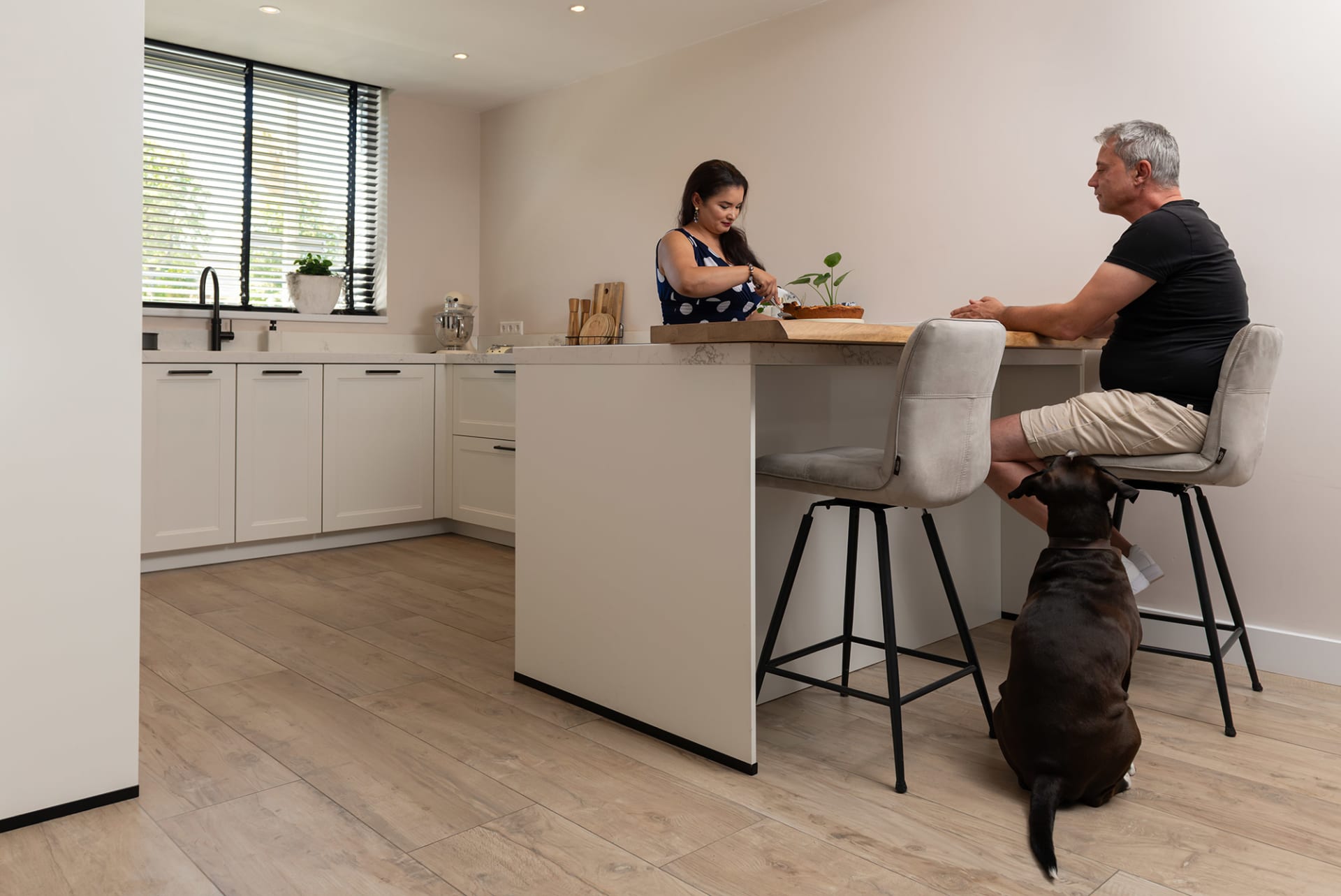 Stel aan het kookeiland in hun lichte keuken van Kitchen4All