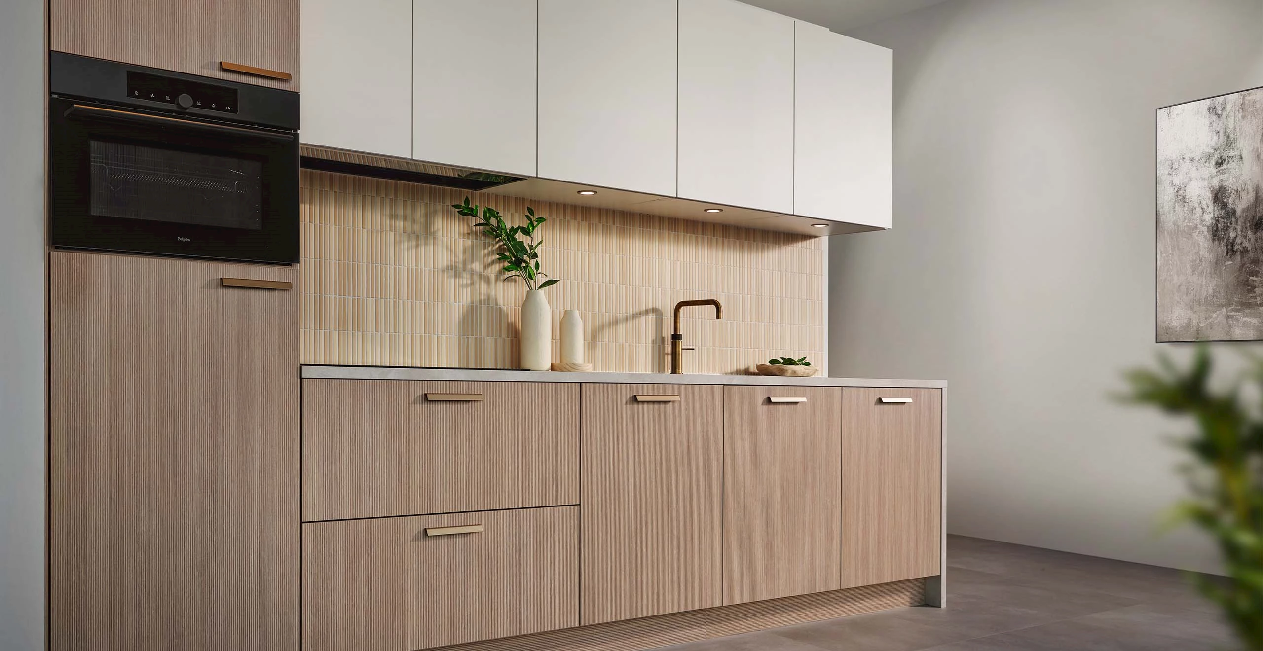 Een lichte keuken met houten onderkasten en witte bovenkasten.